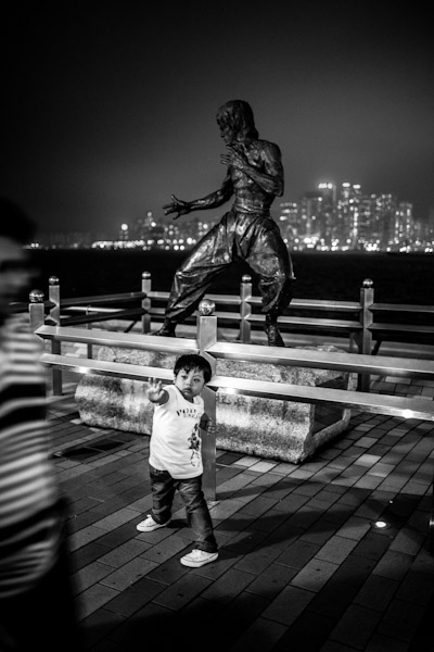 A boy poses in front of Bruce Lee's statue, Avenue of Stars, Hong-Kong